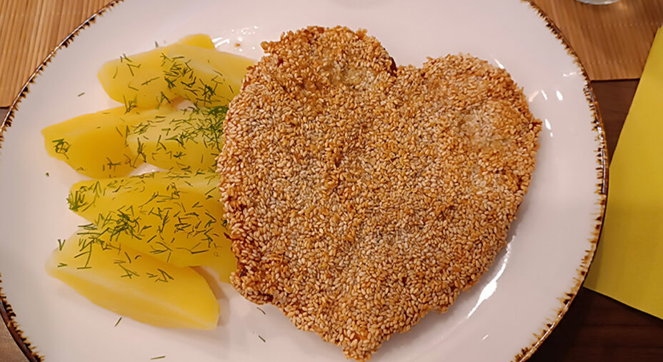 Nella guesthouse Lubar a Dziwnów, la cotoletta avvolta da sesamo con patate e finocchietto e a forma di cuore