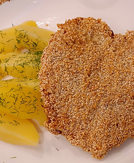 Nella guesthouse Lubar a Dziwnów, la cotoletta avvolta da sesamo con patate e finocchietto e a forma di cuore