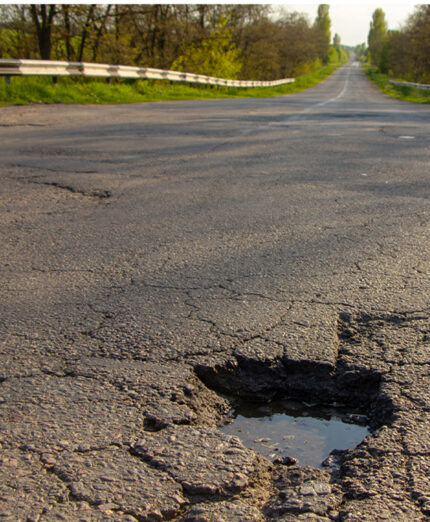 Le buche e l'incuria della strada sono pericoli in quanti tali e perché costringono il ciclista a scartare (depositphotos.com)
