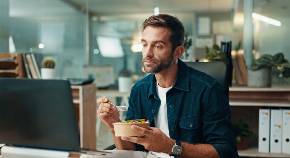 Mangiare è diventato un impegno da incastrare fra gli altri, magari al lavoro e davanti al computer (depositphotos.com)