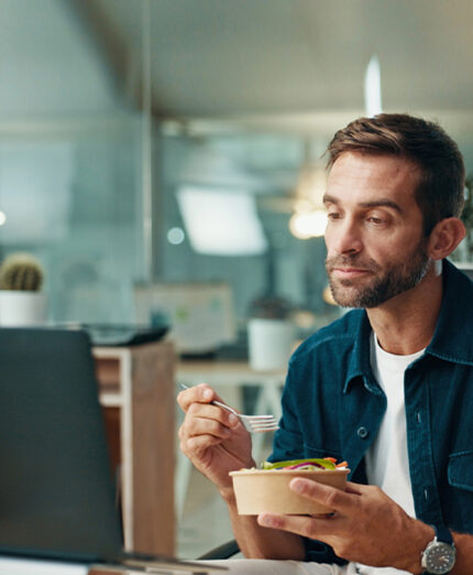 Mangiare è diventato un impegno da incastrare fra gli altri, magari al lavoro e davanti al computer (depositphotos.com)